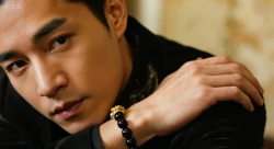 A man wearing a Feng Shui Pixiu bracelet with black obsidian beads, representing wealth and masculine energy.