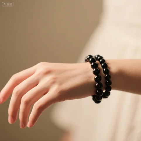 Black obsidian bracelet worn on a hand with soft blurred background